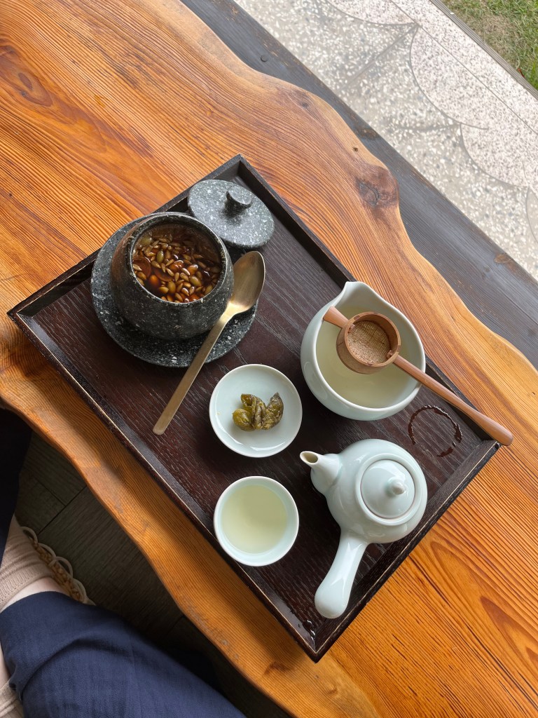 A photo of a tea set that I used in Korea, consisting of teapot, pitcher and cup we well as a black cast iron pot of medicinal herb soup.